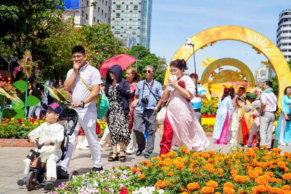 Trẻ nhỏ theo bố mẹ du xuân cũng khá vất vả giữa trưa nắng. Nhiều em bé được phụ huynh trang bị mũ rộng vành, che chắn kỹ lưỡng để tránh say nắng khi di chuyển đường dài.