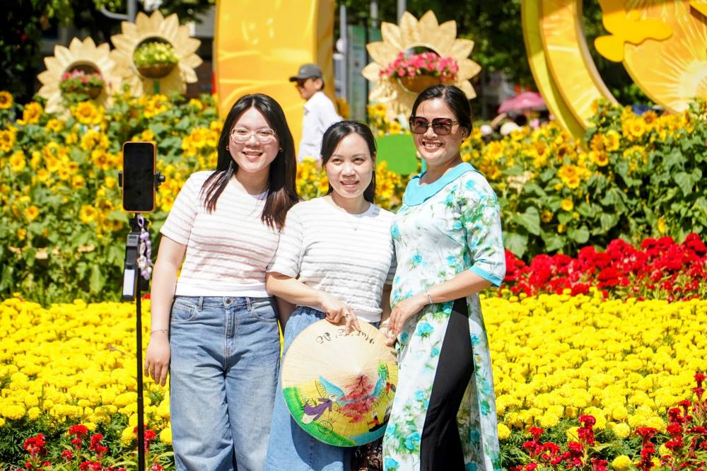 Tuy nhiên, rào cản thời tiết không ngăn được dòng người du xuân. Chị Thiên Trang (ngụ phường Bình Trưng) cùng gia đình có mặt tại trung tâm thành phố từ 11h trưa.Chị Thiên Trang (ngụ Củ Chi) cùng gia đình tranh thủ xuống phố từ trưa. “Vì kẹt công việc buổi sáng nên gần trưa nhà mình mới tới nơi. Nắng thì có nắng nhưng cả nhà vẫn rất vui, tranh thủ chụp nhanh rồi tìm chỗ mát nghỉ ngơi“, chị Trang chia sẻ.