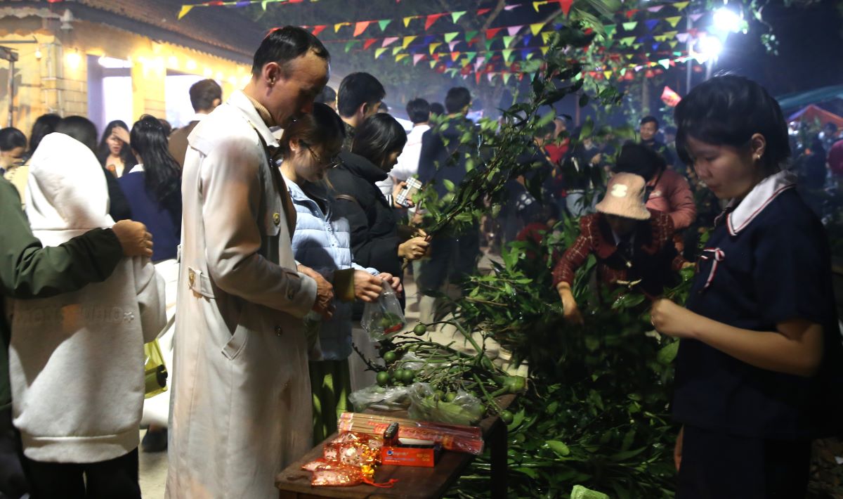 Người dân mua lá chè xanh, lá phát tài được bày bán ở chợ. Ảnh: Hưng Thơ