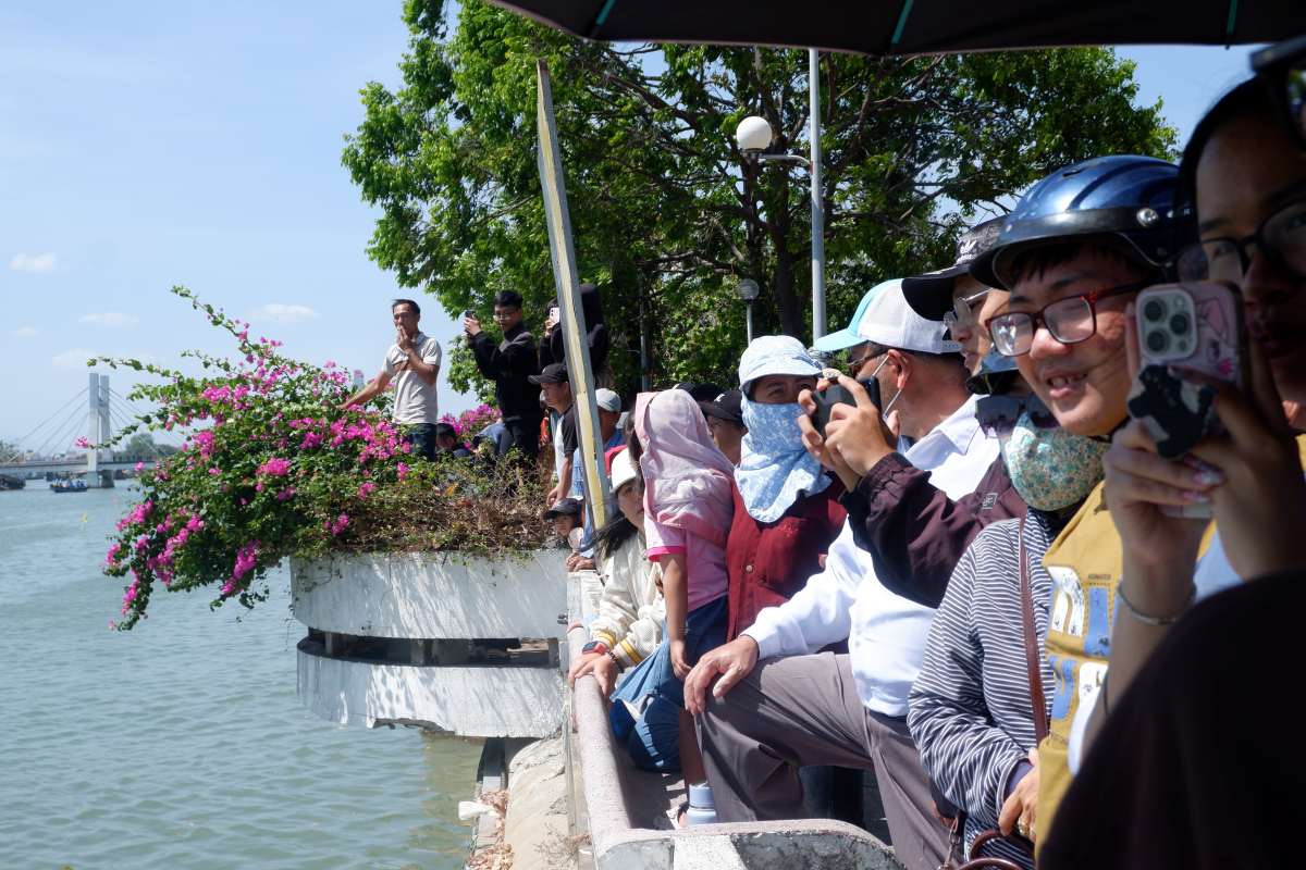 Đông đảo người dân hai bên bờ sông Cà Ty đến xem và cổ vũ cho các vận động viên đua thuyền. Ảnh: Minh Tâm