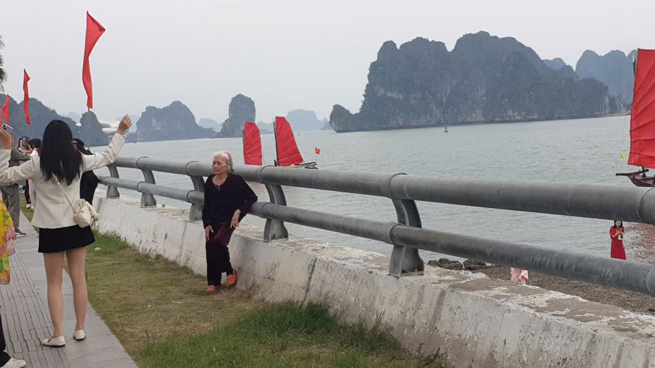 Con cháu phải thuyết phục mãi cụ mới chụp ảnh với thuyền buồm. Ảnh: Nguyễn Hùng