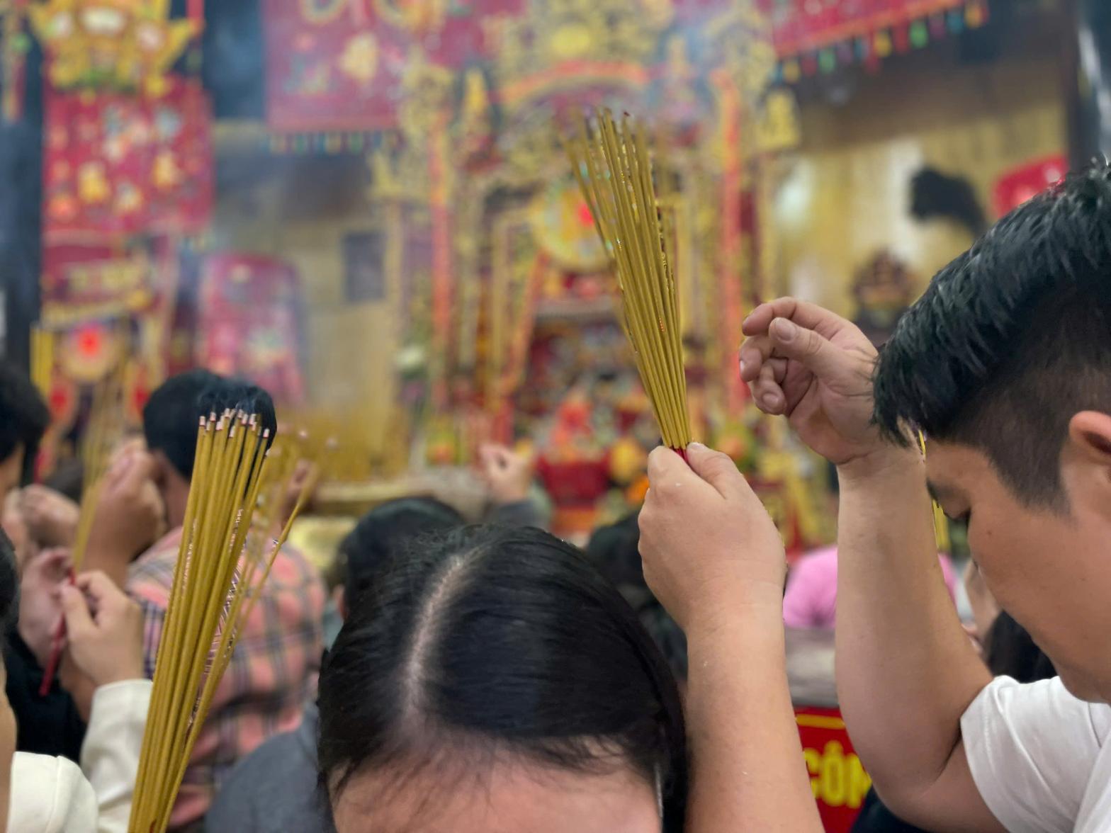 Nhiều người cầm cả nắm nhang len vào bên trong chính điện. Ảnh: Đình Trọng