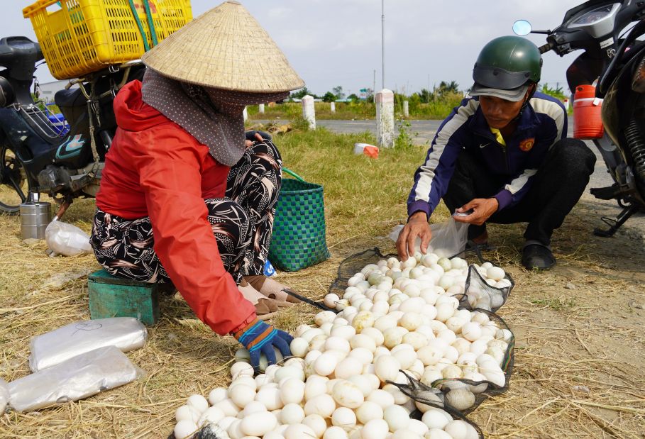 Bà Thu tranh thủ mang trứng vịt đi bán lẻ sau buổi sáng thả vịt ngoài đồng. Ảnh: Phương Anh