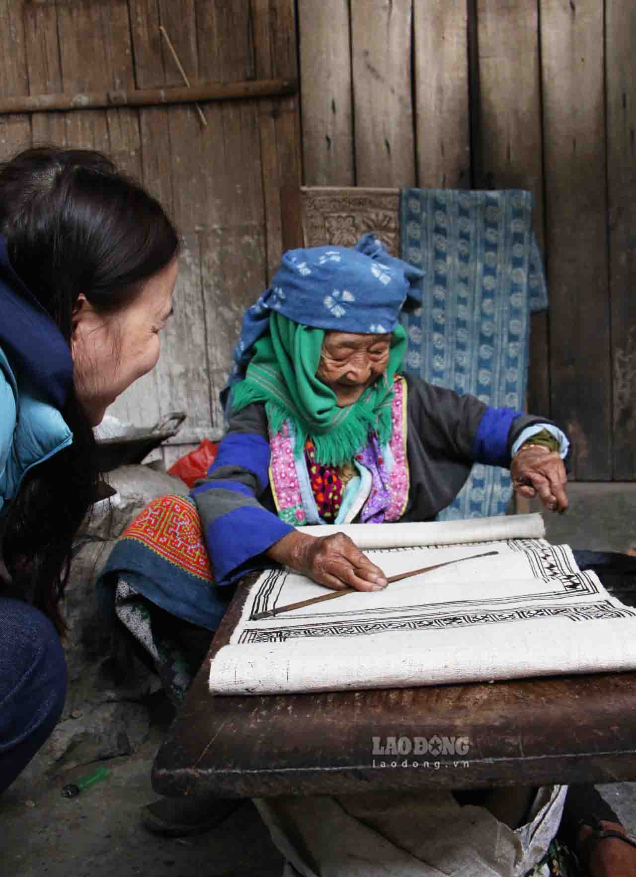 Nghệ nhân Sùng Thị Cờ rất hào hứng chia sẻ với du khách về nghề truyền thống của người Mông. Ảnh: Nguyễn Tùng.