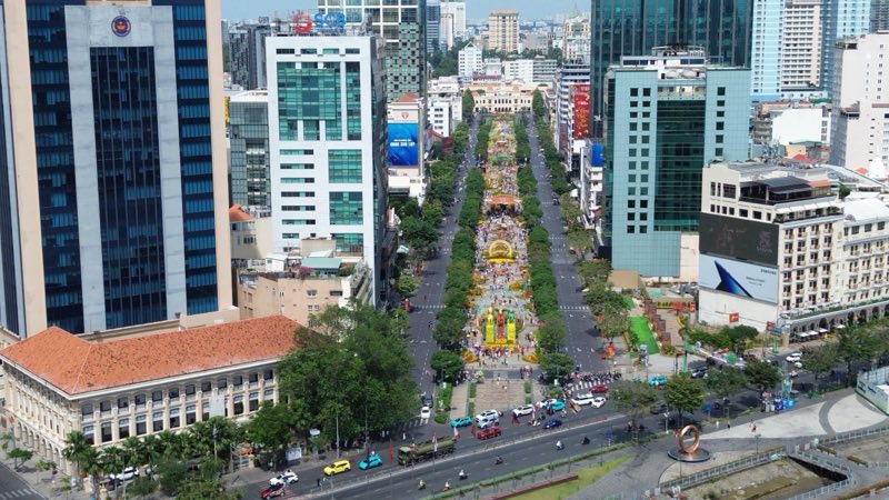 Đường hoa Nguyễn Huệ đông đúc khi hàng trăm người dân xúng xính áo dài xuống phố check-in cùng linh vật năm mới. Ảnh: Anh Tú