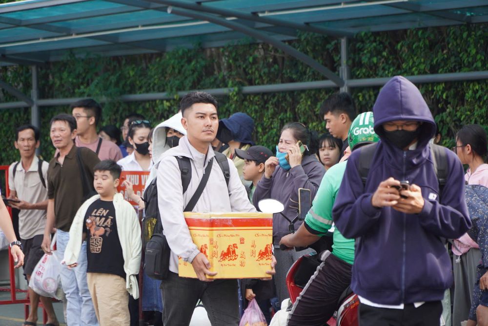 Người dân lỉnh kỉnh mang theo nhiều hành lý rời bến xe, chờ đón xe để về nhà. 