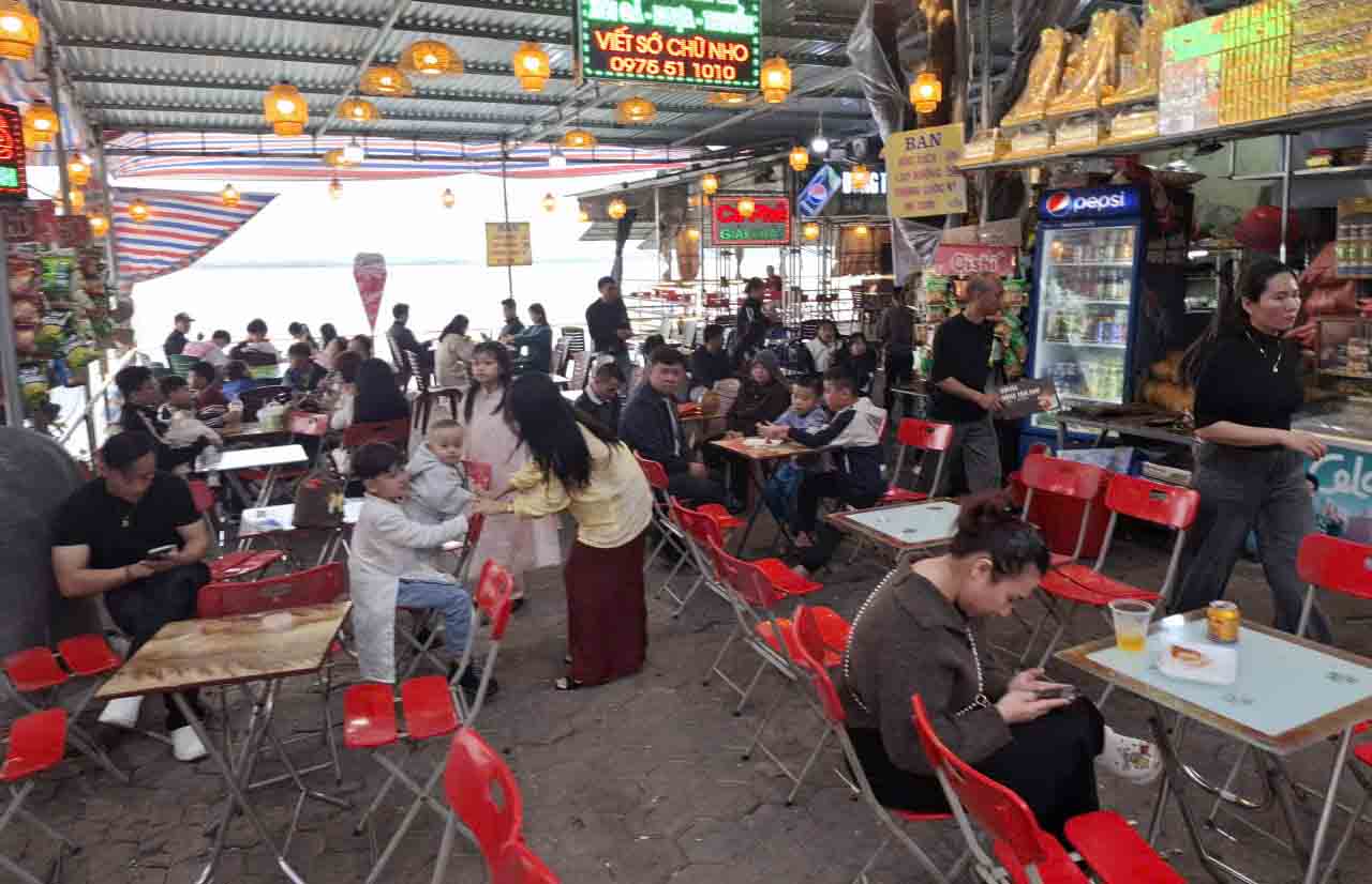 Nhiều người nghỉ ngơi, uống nước sau khi đến Đền Chợ Củi dâng hương