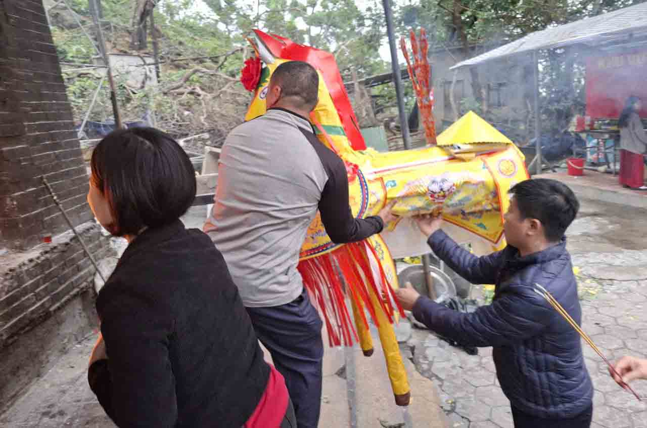 Bringing paper horses into the votive paper burning furnace at Cho Cui Temple. Photo: Tran Tuan
