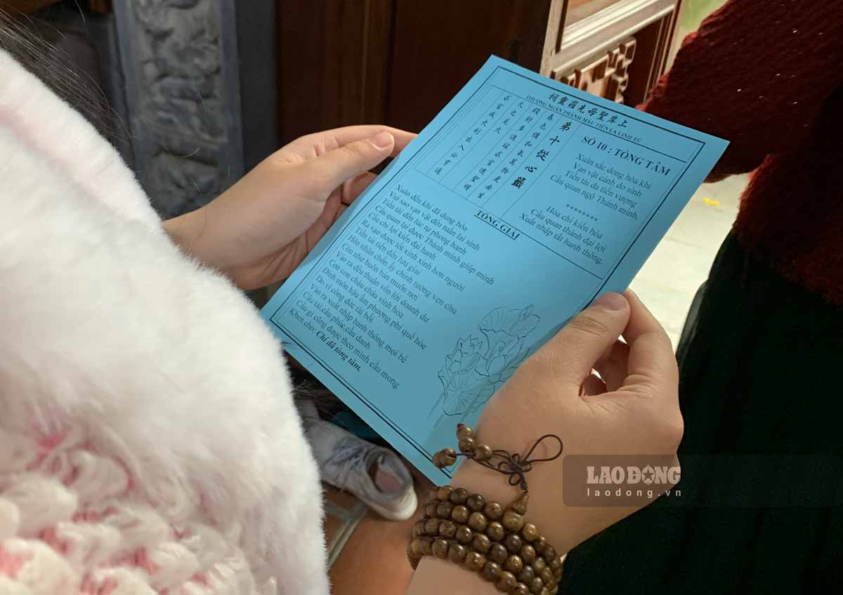 Người dân xếp hàng dài khu vực bên trong đền chờ bốc được bốc quẻ thẻ. Ảnh: Lương Hà