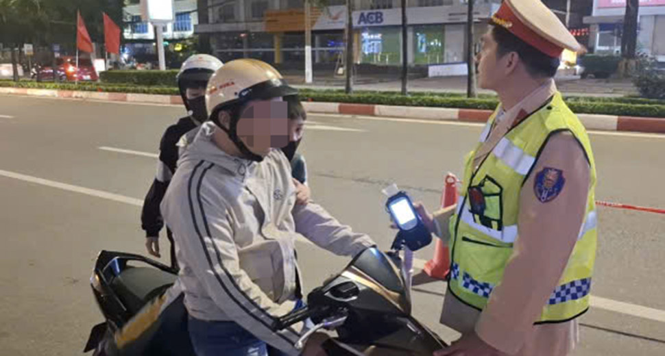 This man violated the alcohol concentration limit when driving a motorbike carrying two young children. Photo: Tran Tuan.