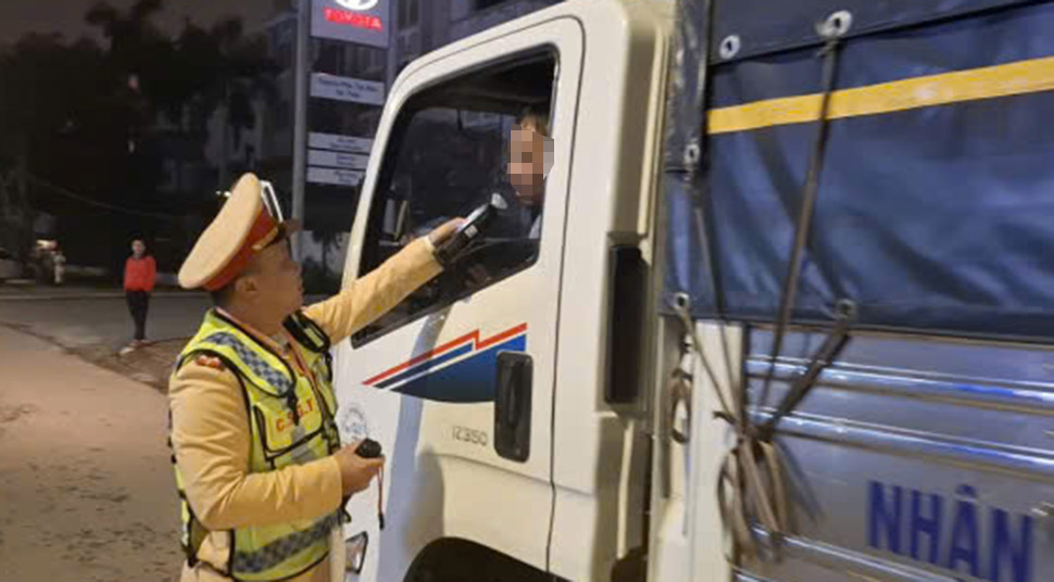 Kiểm tra nồng độ cồn với tài xế xe tải. Ảnh: Trần Tuấn