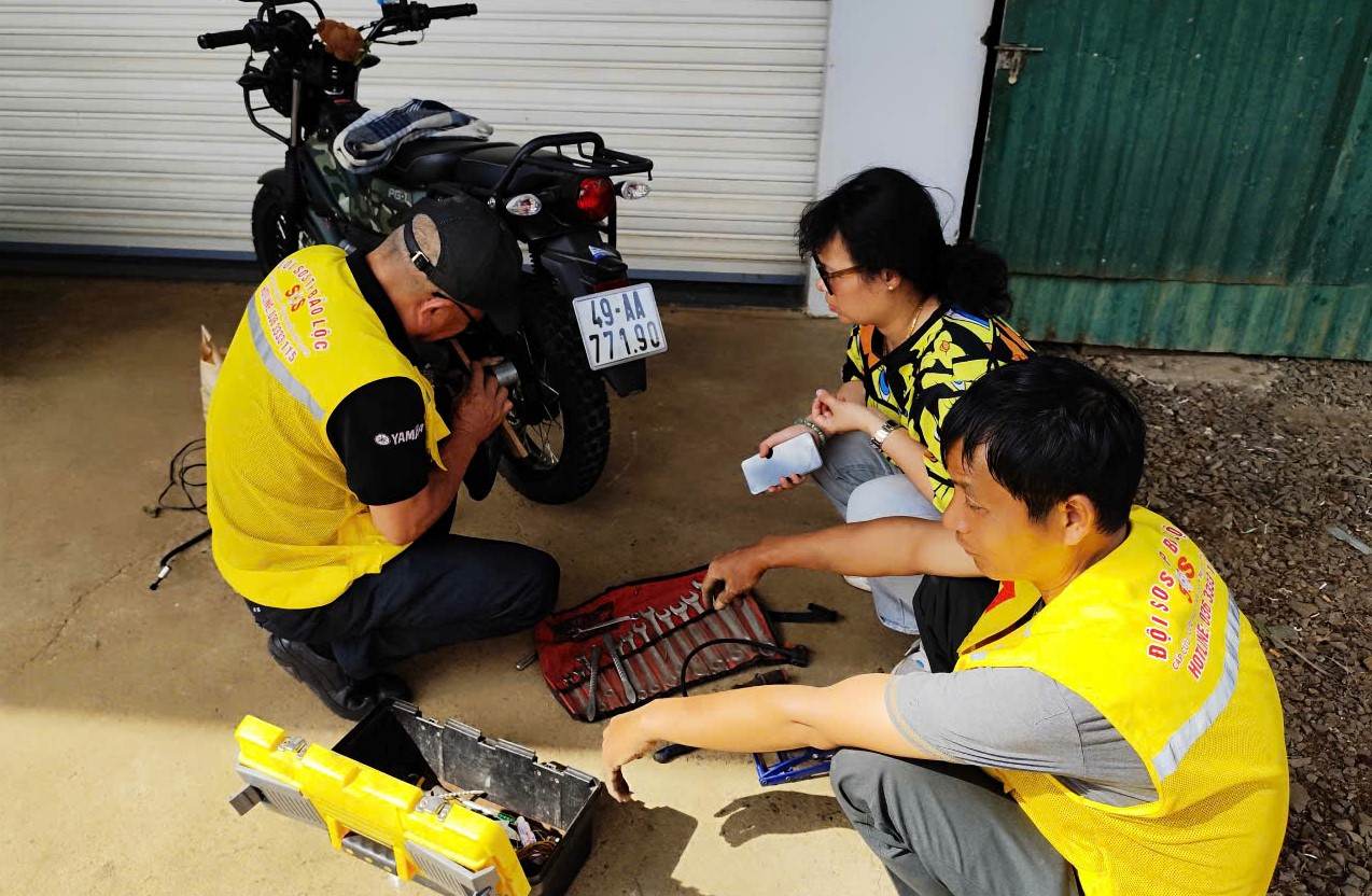 Chiều mùng 3 Tết, một người dân đi du xuân bị thủng săm được Đội SOS Bảo Lộc kịp thời có mặt vá xe miễn phí. Ảnh: Hải Đường 