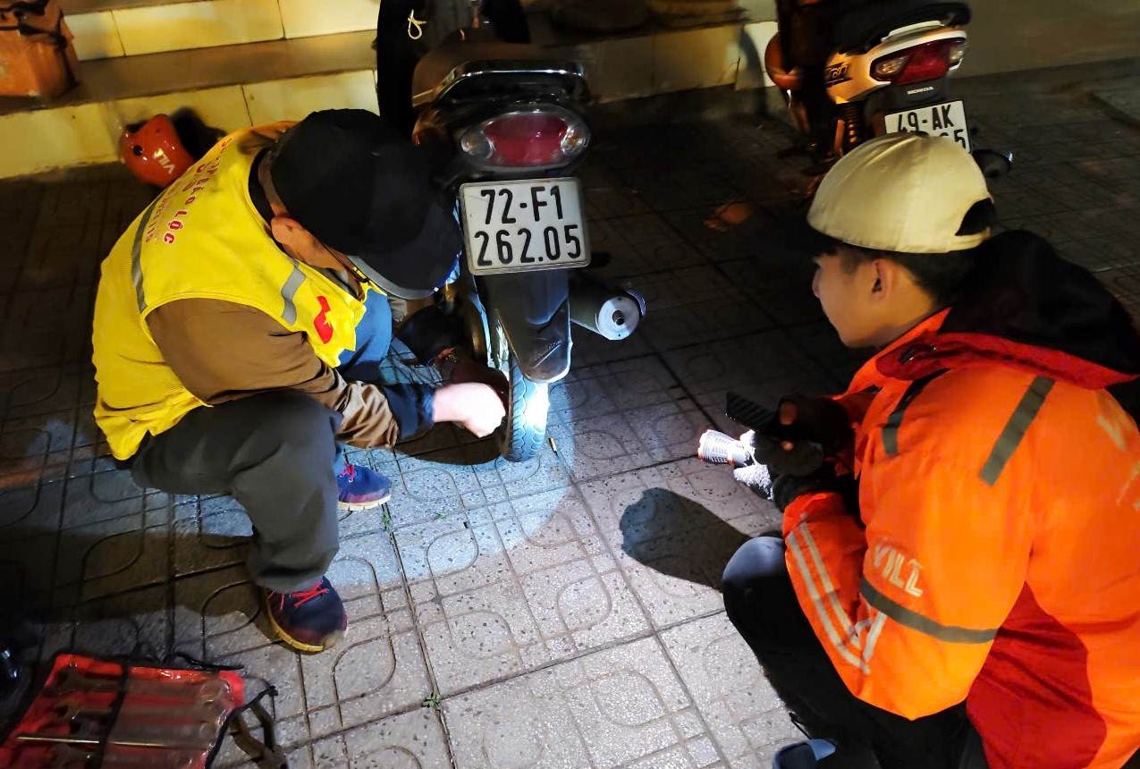 Đêm mùng 3 Tết, một du khách đang trên đường lên Đà Lạt du xuân thì xe bị thủng săm được đội SOS Bảo Lộc hỗ trợ vá miễn phí để tiếp tục hành trình. Ảnh: Hải Đường 