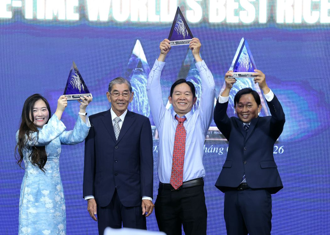 Labor Hero Ho Quang Cua and his children lift the "World's Best Rice" cup in 2025. Photo: Trung Pham