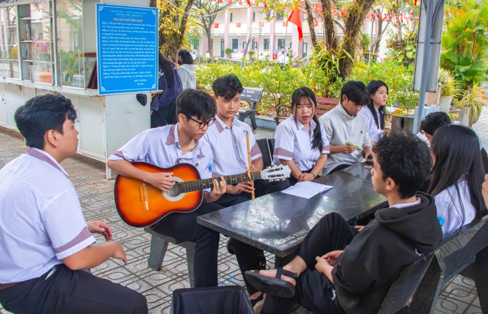 Nhóm bạn học sinh cùng nhau đàn hát, trò chuyện vui vẻ trong thời gian nghỉ giải lao. Ảnh: Khánh Vân