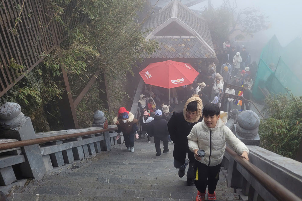 Dòng người tấp nập leo đỉnh Fansipan trong điều kiện thời tiết lạnh giá và sương mù. Ảnh: Thanh Phong