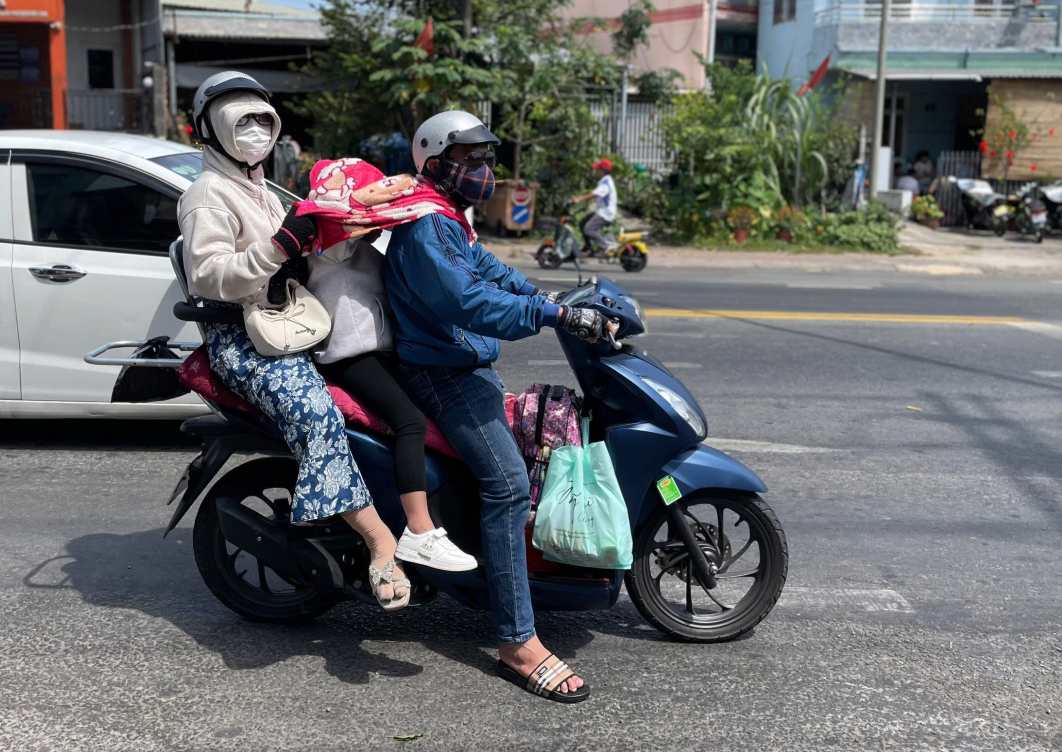 Trời nắng nóng nên việc đi lại bằng xe máy rất vất vả. Ảnh: Đình Trọng