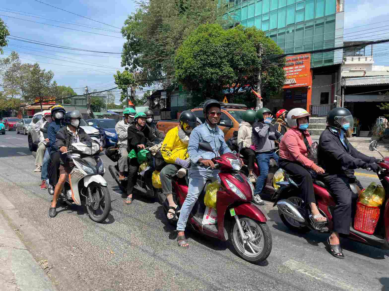 Workers brave the sun by motorbike back to Ho Chi Minh City. Photo: Dinh Trong