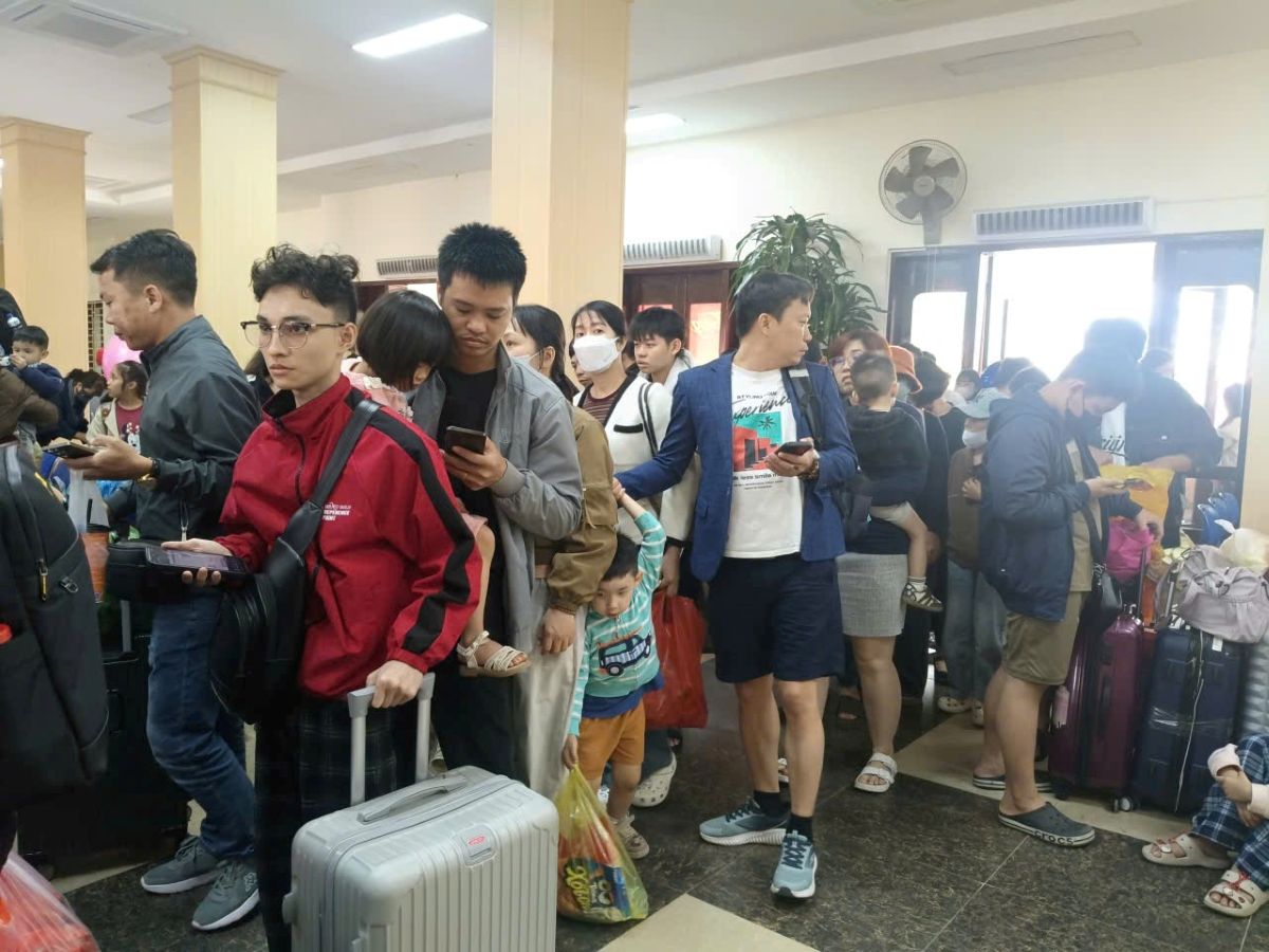 Người dân lỉnh kỉnh đồ đạc, xếp hàng tại nhà ga sau kỳ nghỉ Tết cùng gia đình. Ảnh: Quách Du