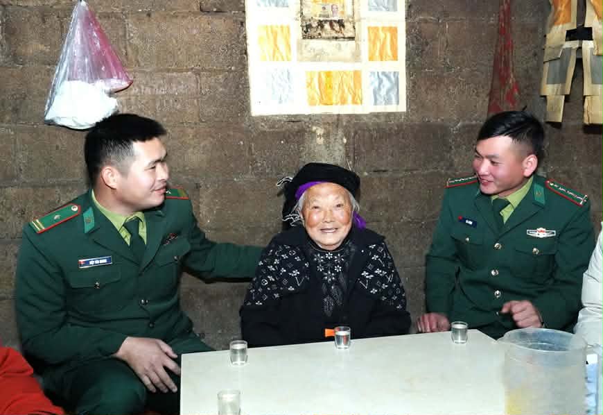 Cán bộ Trạm kiểm soát Biên phòng Xín Cái cùng đồng đội thăm, chúc Tết tại thôn Mỏ Phàng, xã Sơn Vĩ. Ảnh: Hà Linh