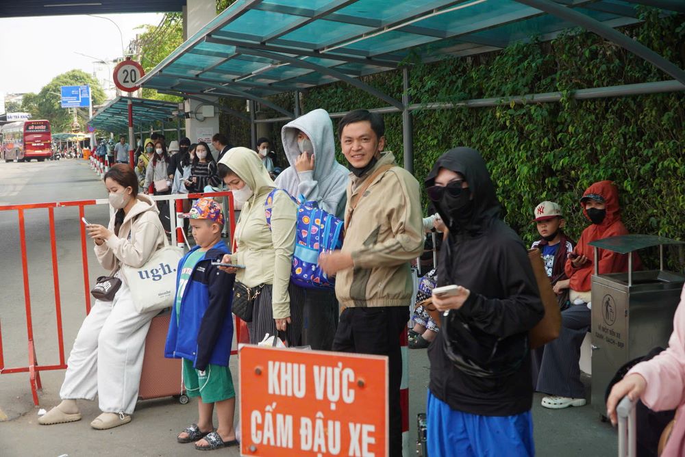 Người dân tay xách nách mang rời bến xe, chờ xe công nghệ, ta xi hay người thân tới đón.