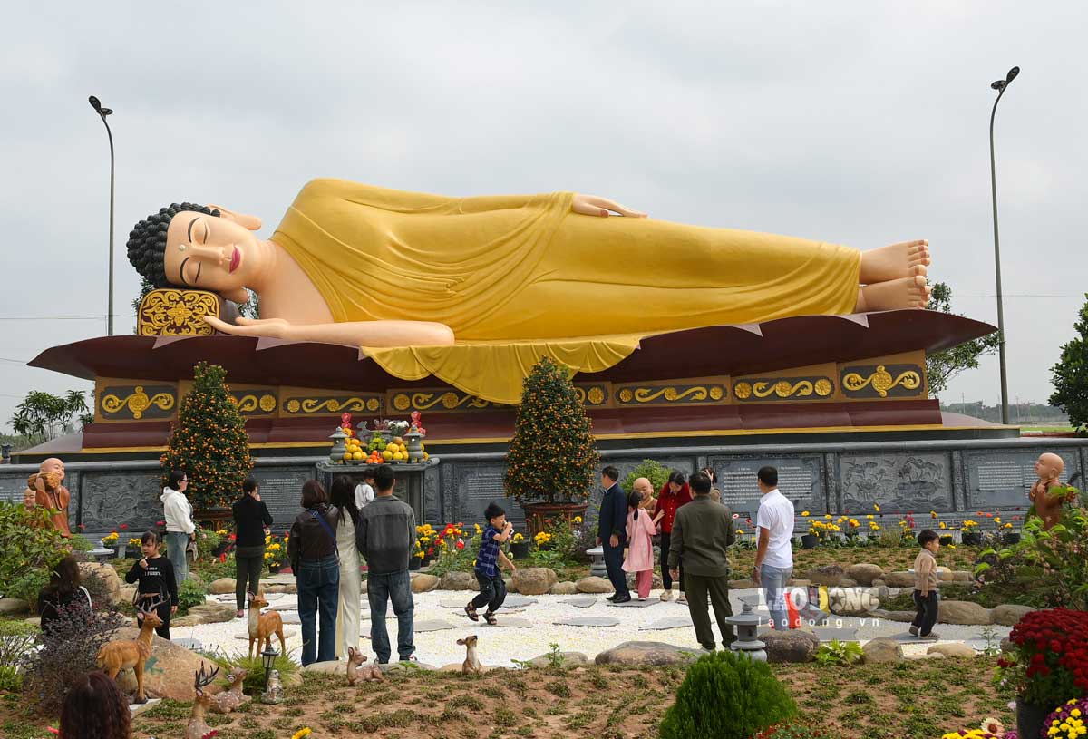 Du khách chiêm bái tượng Đức Phật nhập niết bàn dài 20m trong khuôn viên chùa. Ảnh: Lương Hà