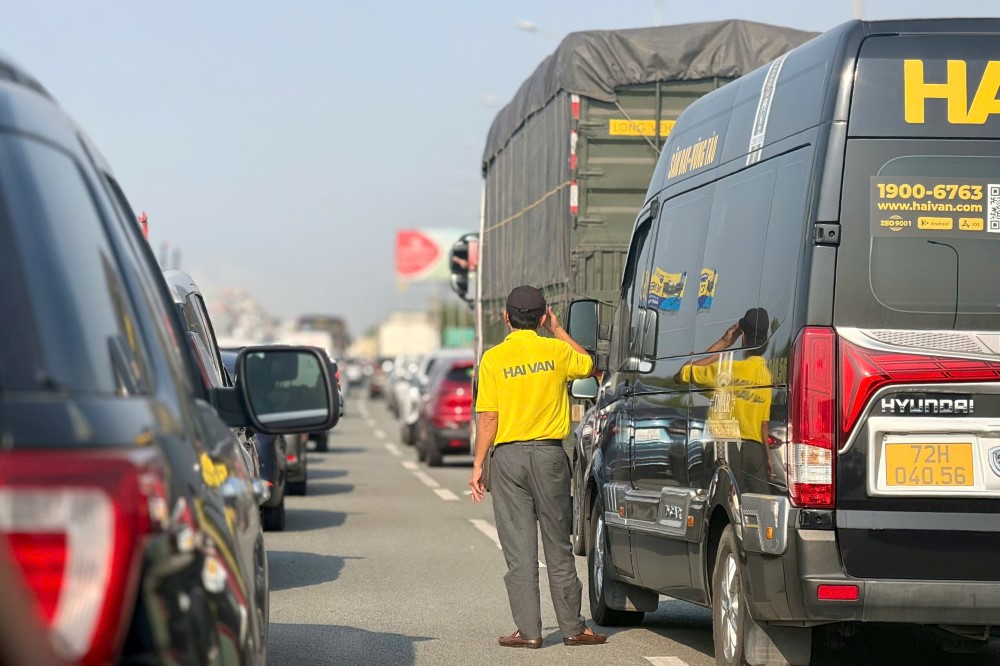 Một số tài xế mệt mỏi đành bước xuống xe chờ đợi. Ảnh: Huệ Thy