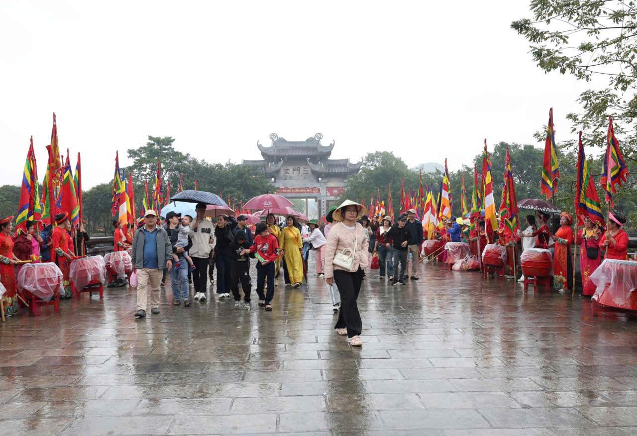 Pilgrims from all directions brave the rain to worship Buddha, visiting Bai Dinh Pagoda on the opening day of the festival. Photo: Dieu Anh