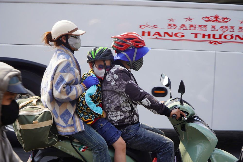 Trẻ nhỏ ngủ gật trên xe máy giữa thời tiết nắng nóng. 