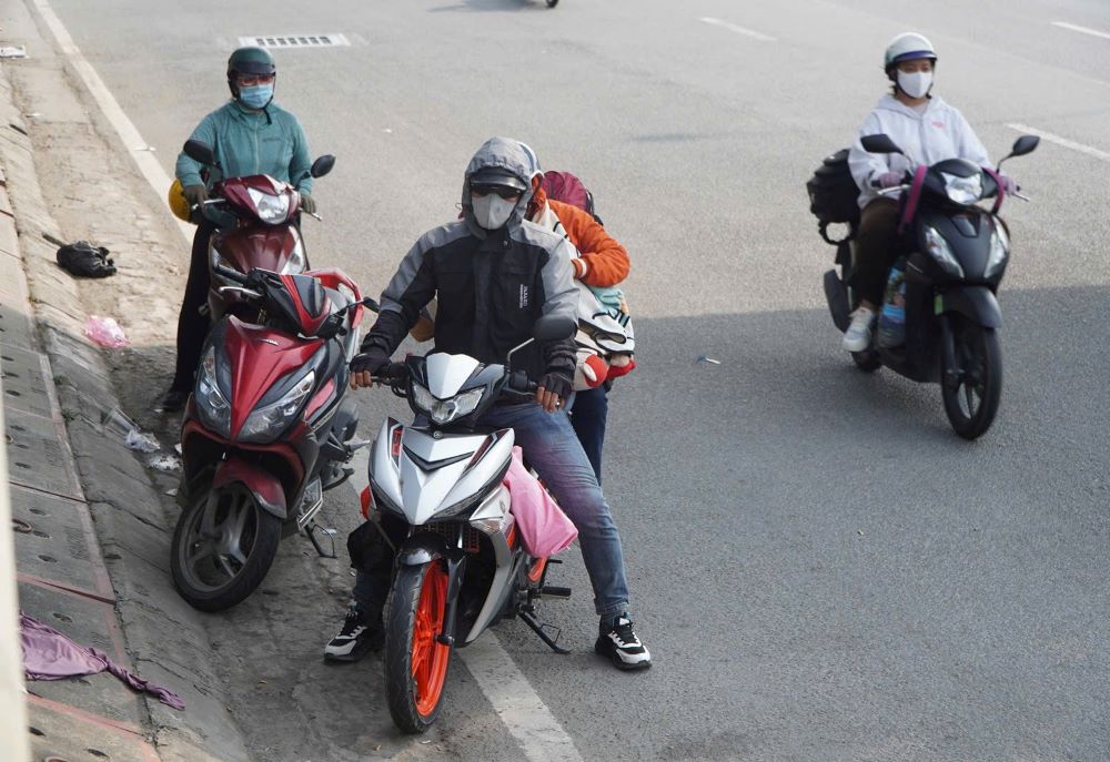 Người dân dừng chân dưới gầm cầu vượt bộ hành trên Quốc lộ 1 để nghỉ mệt giữa trưa nắng.