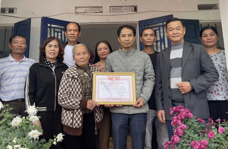 Mr. Le Van Loi, Head of Do Xa residential group, on behalf of the local government, handed over the Certificate of Longevity to Mrs. Nguyen Thi Lan (80 years old). Photo: Quynh Trang