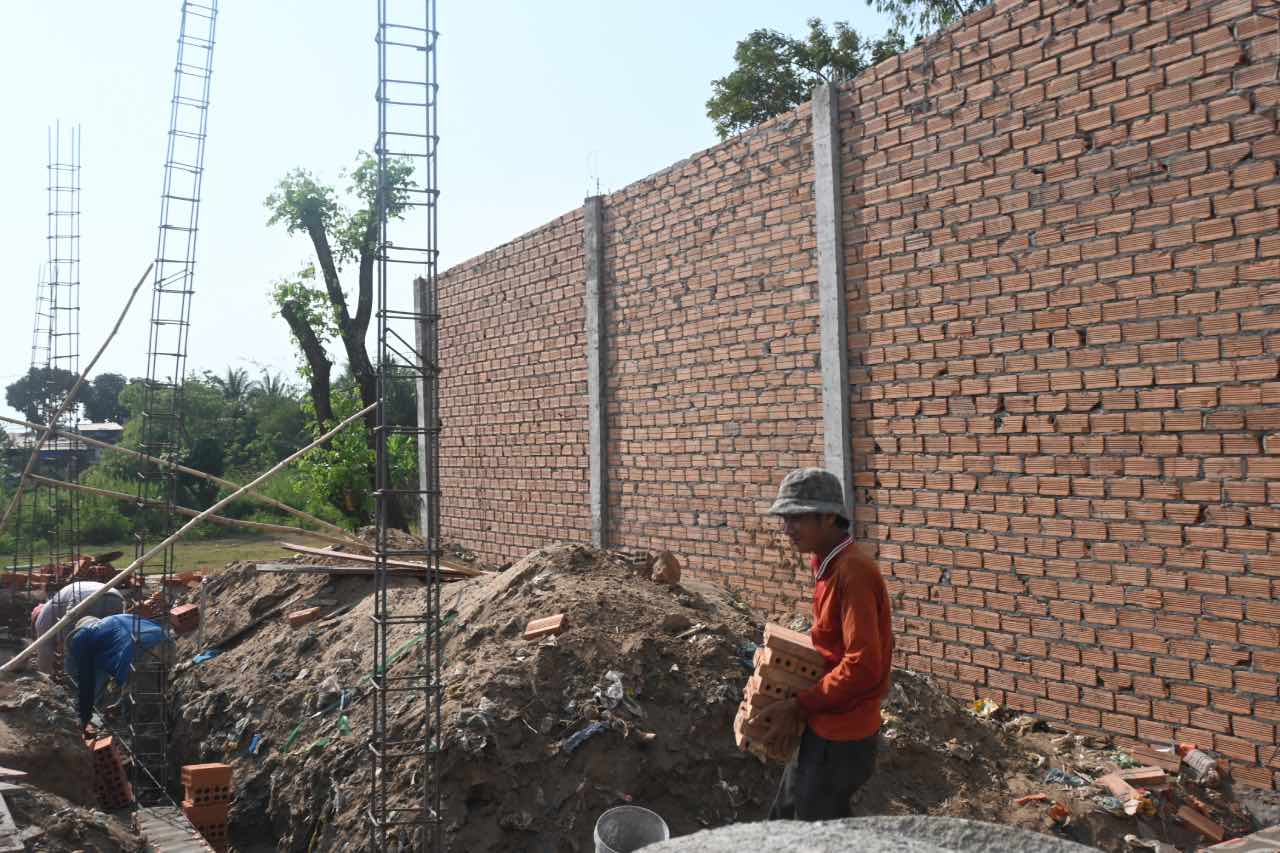 Công nhân khẩn trương thi công 15 căn nhà “Đại đoàn kết” tại ấp Vĩnh Phước. Ảnh: Thành Nhân