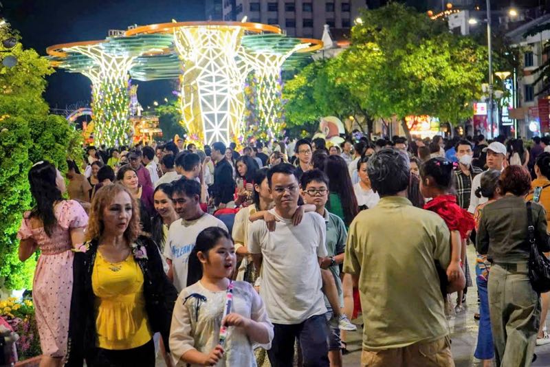Không còn chỗ trống trên các lối đi bộ, người dân chen chân thưởng lãm phiên bản trải nghiệm đêm lung linh của đường hoa. Ảnh: Anh Tú