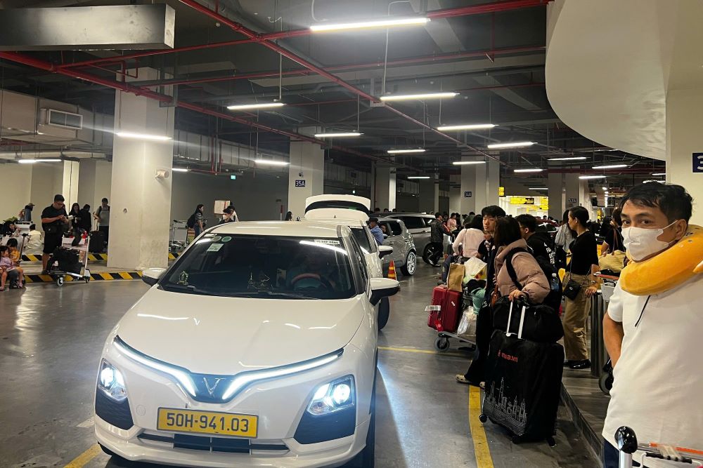 Người dân lỉnh kỉnh đồ đạc, hành lý kiên nhẫn xếp hàng chờ taxi, xe công nghệ tại khu vực bãi đỗ xe sân bay.