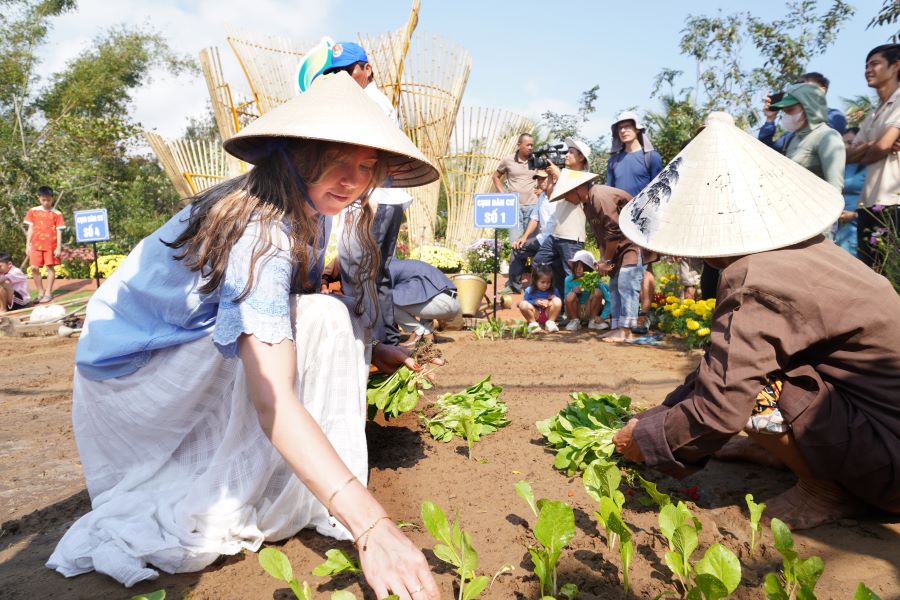International tourists experience vegetable fertilization and watering at Tra Que Vegetable Village on the first day of spring