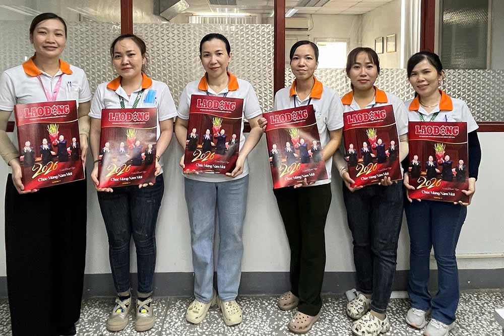 Công nhân Công ty TNHH Giầy Ching Luh Việt Nam nhận ấn phẩm xuân Lao Động. Ảnh: Nguyễn Khải