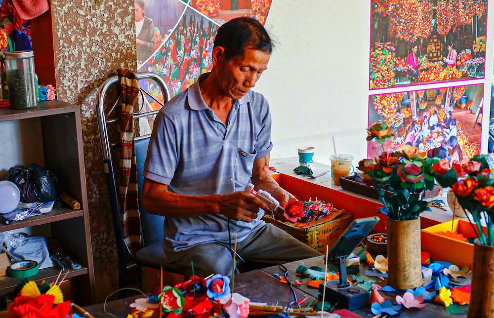 Ông Trần Phú (64 tuổi), nghệ nhân có hơn 40 năm gắn bó với nghề cho biết gia đình ông đã ba đời làm hoa giấy. “Nghề này cần sự kiên trì, tỉ mỉ. Làm nhanh không được, mà thu nhập cũng bấp bênh nên lớp trẻ ít theo”, ông chia sẻ.