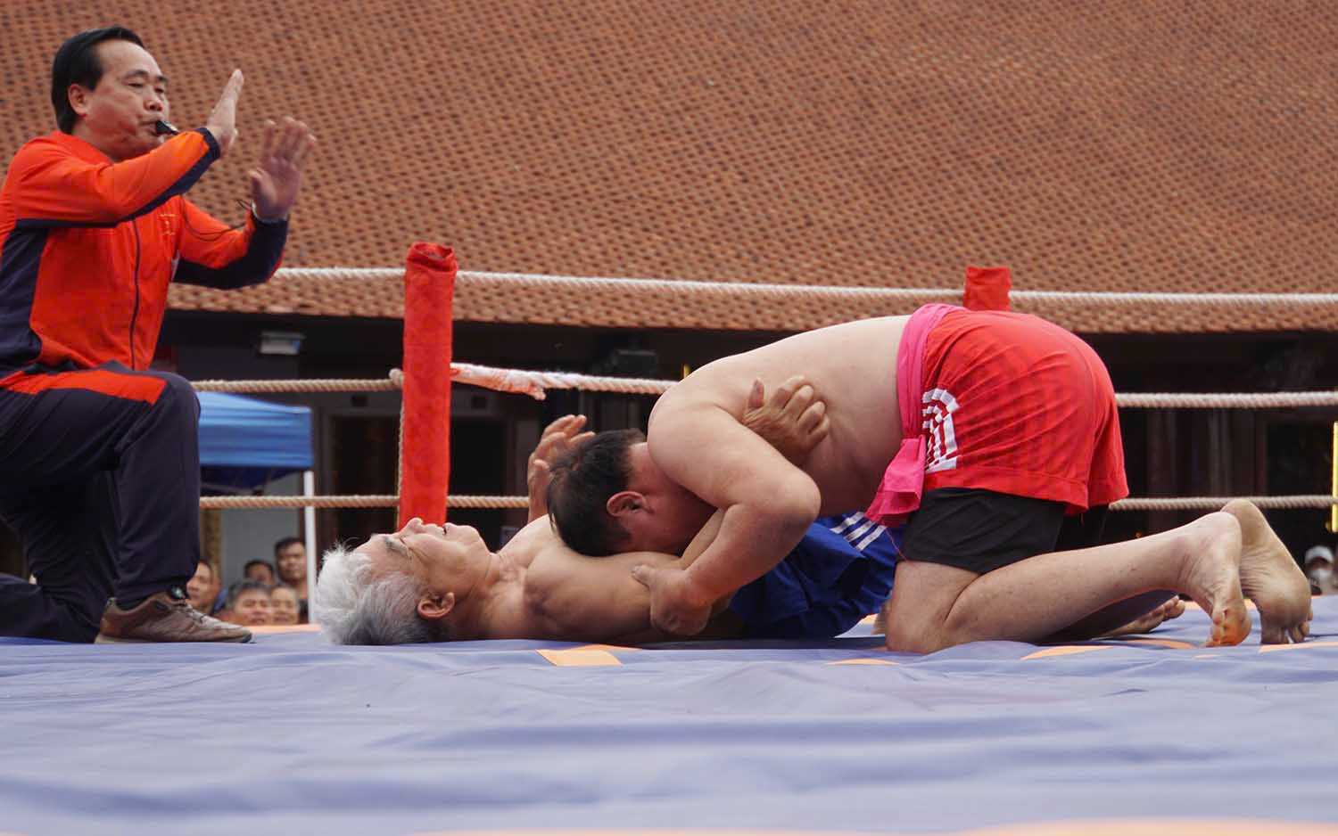 Các đô vật tranh tài quyết liệt trong tiếng reo hò cổ vũ của khán giả. Ảnh: Hải Minh