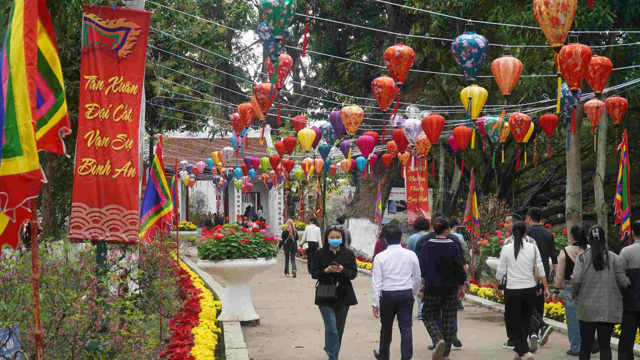 Dòng người tấp nập nối dài trước sân đền, ai nấy đều chuẩn bị hương hoa, dâng lễ với mong ước vạn sự hanh thông. Ảnh: Minh Vũ