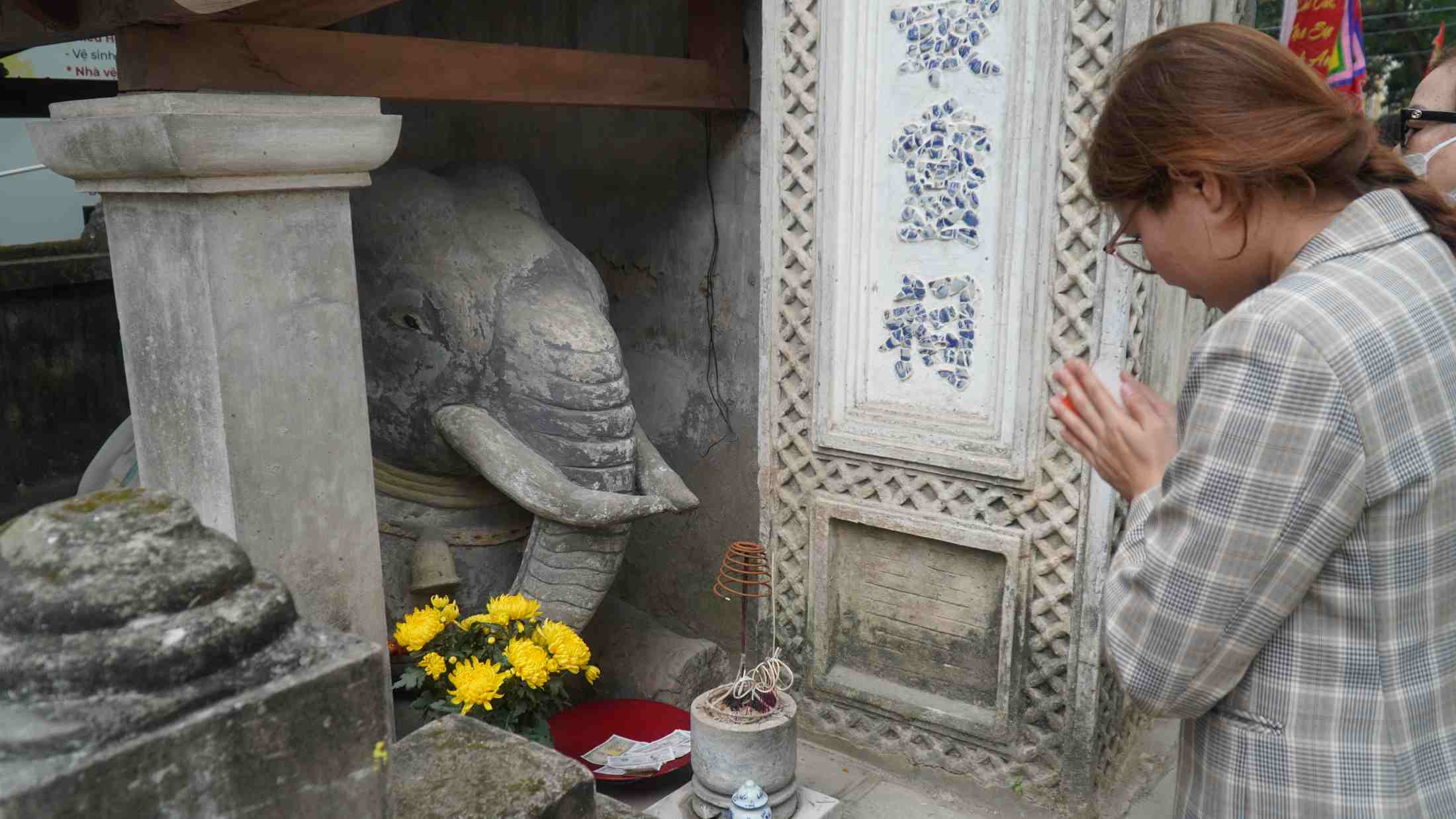 Du khách lễ trước tượng vui phục ở cửa đền. Ảnh: Minh Vũ