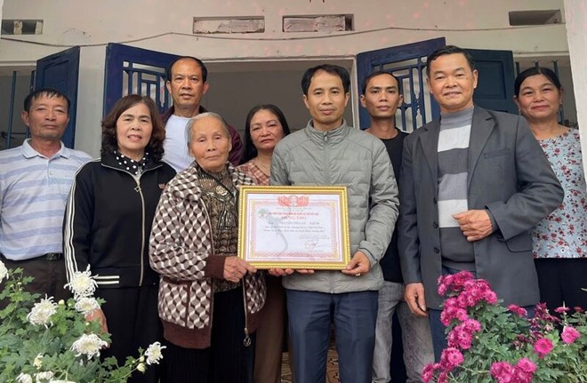 Mr. Le Van Loi, Head of Do Xa residential group, on behalf of the local government, handed over the Certificate of Longevity to Mrs. Nguyen Thi Lan (80 years old). Photo: Quynh Trang