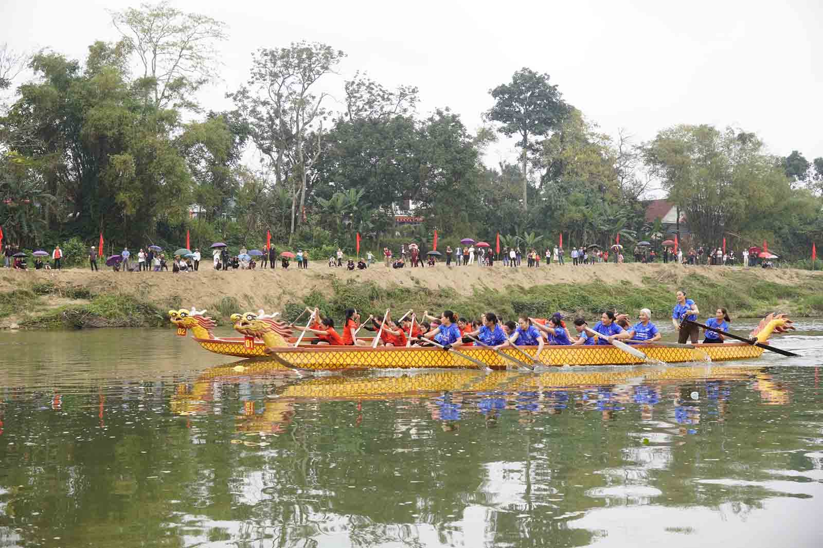 People cheer for boat racing on the Ngan Pho River. Photo: Kha Son