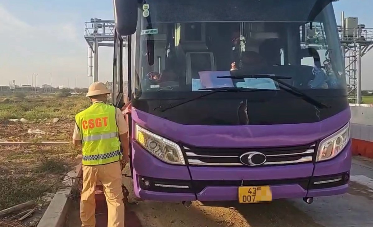 Cảnh sát Giao thông dừng xe khách kiểm tra và phát hiện chở quá số người quy định. Ảnh: Phạm Duy 