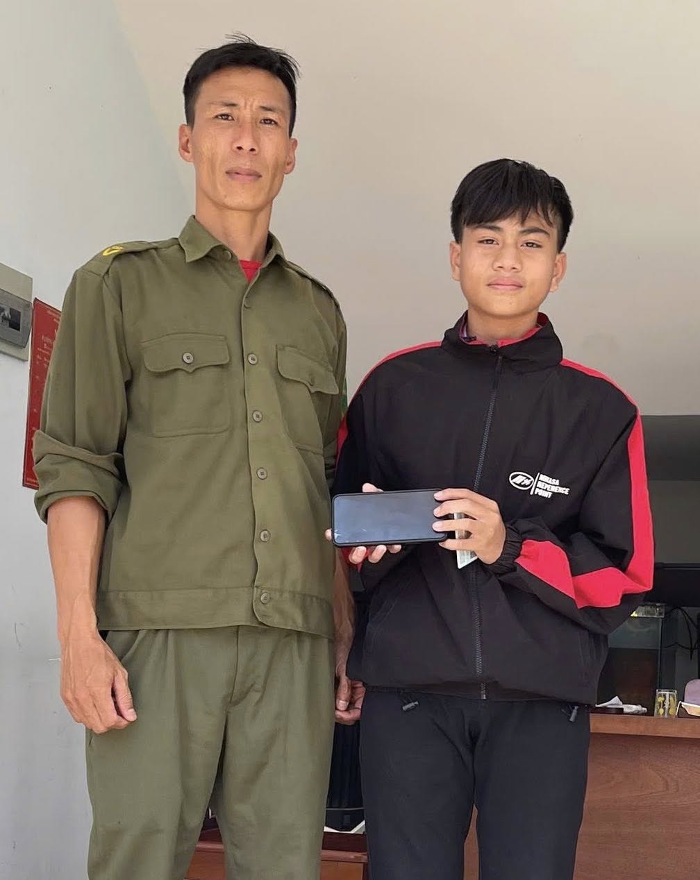 The person who dropped the property receives back the lost phone. Photo: Nam Ninh Hoa Commune Police
