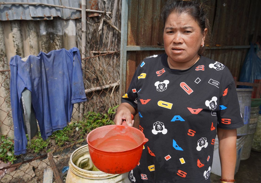 Bà Trần Thị Xuân Hiền bơm nước giếng, xử lý bằng phèn để sử dụng tạm do thiếu nước máy. Ảnh: Hậu Giang