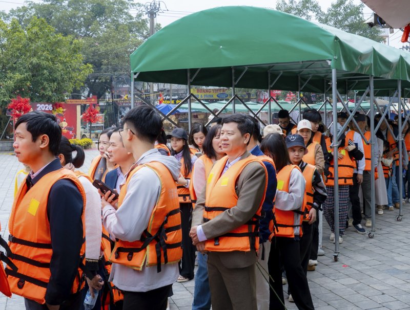Du khách xếp hàng mặc áo phao trước khi xuống đò tại khu du lịch Tam Cốc - Bichs Động. Ảnh: Diệu Anh