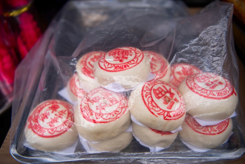 Bên cạnh vàng mã, các sạp chuyên doanh bánh đặc trưng của người Hoa cũng tất bật phục vụ. Bánh bao tạo hình túi tiền, đào tiên hay thỏi vàng là những lễ vật được nhiều người lựa chọn để dâng cúng Thần Tài