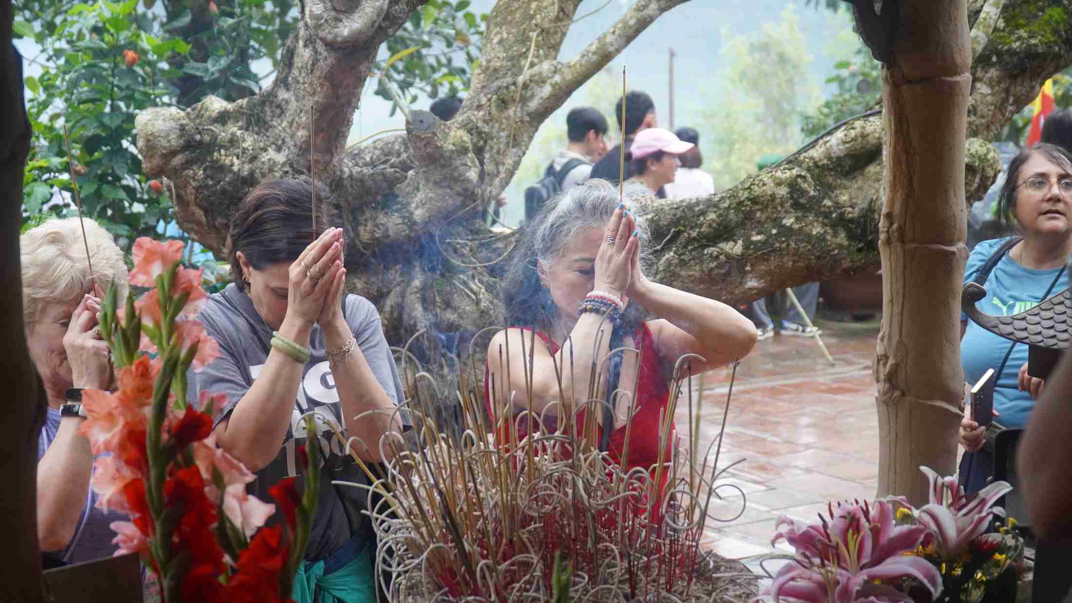 Du khách nước ngoài học phong tục, lắng nghe lịch sử và thắp hương tại chùa Giải oan trong khuôn viên Yên Tử. Ảnh: Minh Vũ