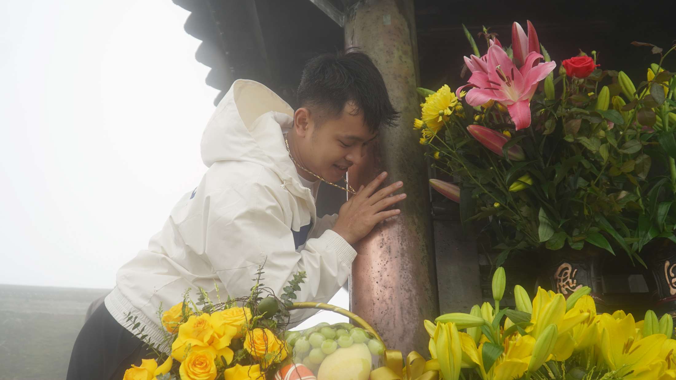 Anh Tài vui vẻ xoa vòng vàng cùng tiền mặt để cầu may mắn, mong công việc hanh thông tại Chùa Đồng. Ảnh: Minh Vũ