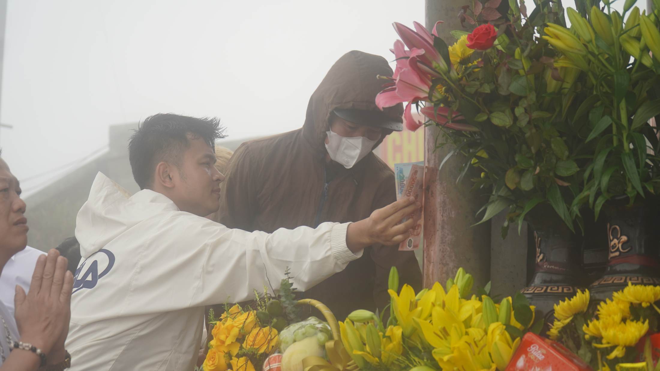 Hình ảnh người dân thực hiện tục lệ xoa tiền cầu may, xin lộc đầu năm tại Chùa Đồng trên đỉnh Yên Tử. Ảnh: Minh Vũ